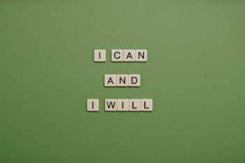 Inspirational message 'I Can and I Will' spelled with tile letters on a green background.